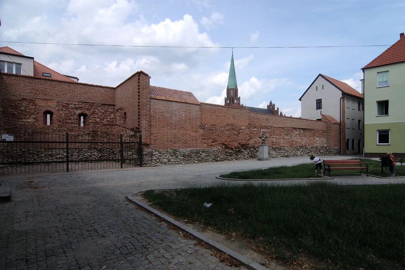 Odcinek ceglanych murów obronnych na kamiennym fundamencie przy ulicy Korczaka.