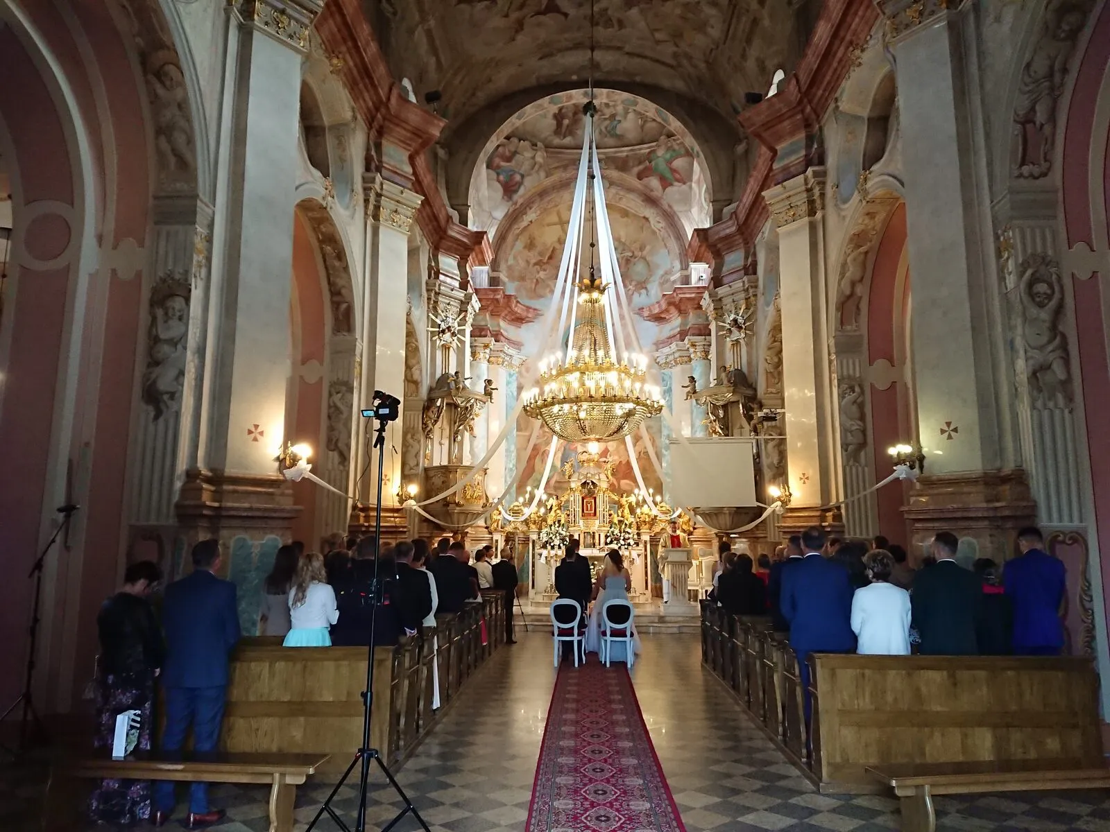 Malowane, późnobarokowe wnętrze bazyliki Świętej Trójcy w Kobyłce z prezbiterium i ołtarzem głównym