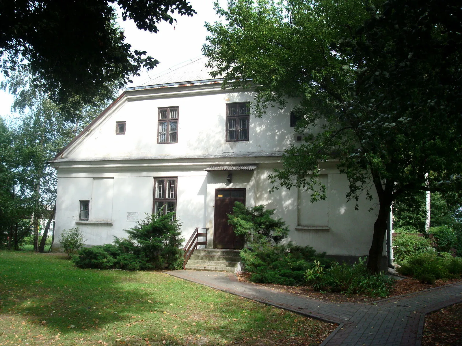 Dwór zwany Sienkiewiczówką w Poświętnem pod Płońskiem: parterowy budynek z tarasem od frontu i boniowaną elewacją, nakryty dachem naczółkowym.