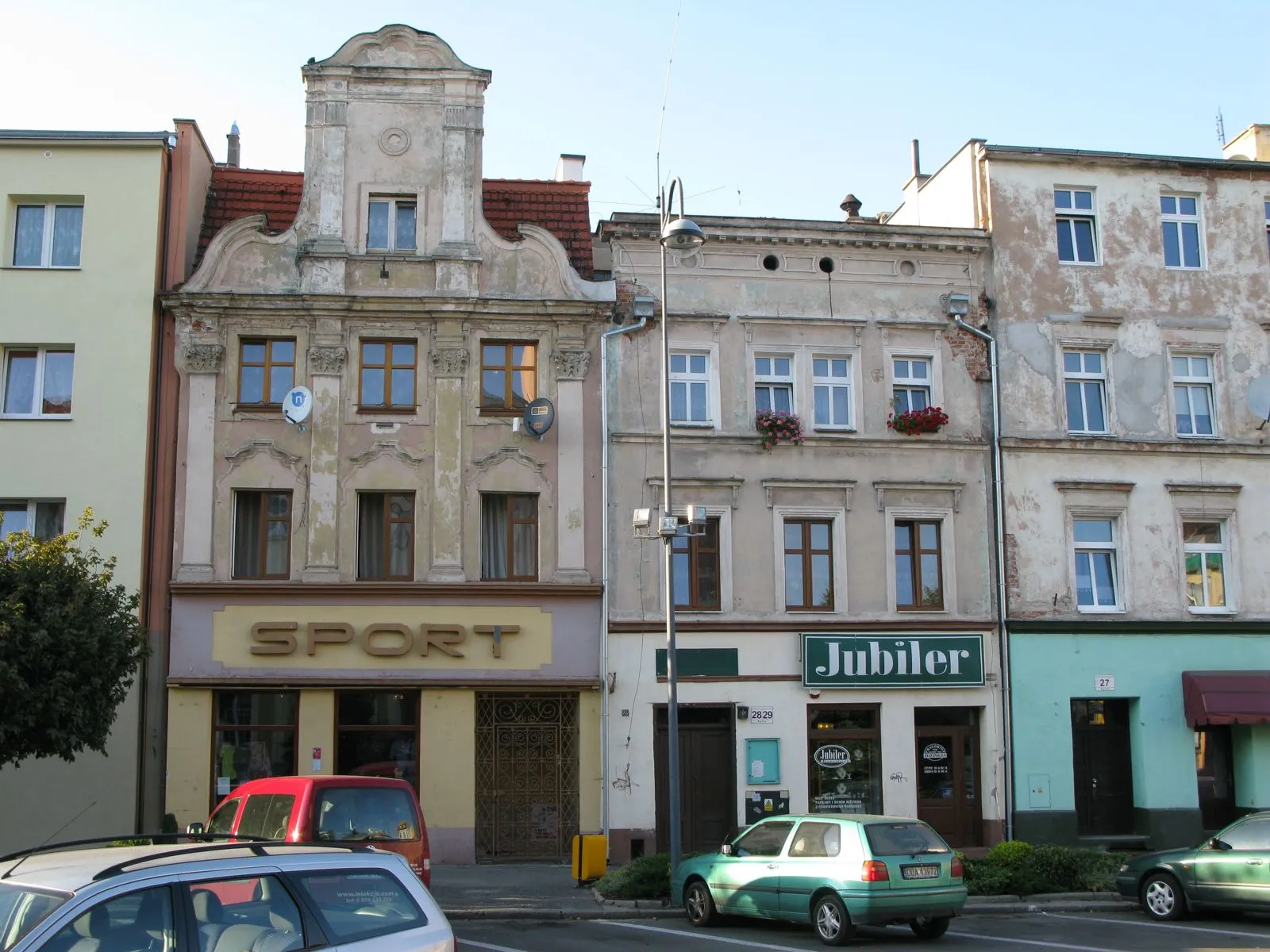 Kamienica przy Rynku 29 w Oławie z pionowymi filarami na fasadzie i ozdobnym szczytem.