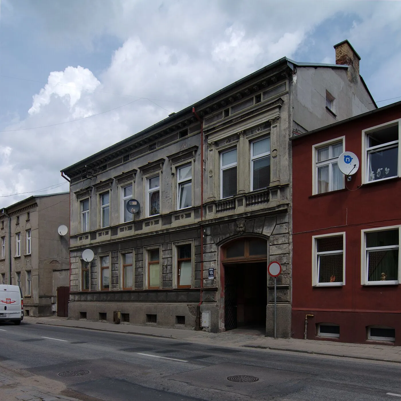 Kamienica przy ulicy Kossaka 15 z sklepionym przejazdem bramnym i ozdobnymi oknami nad nim.