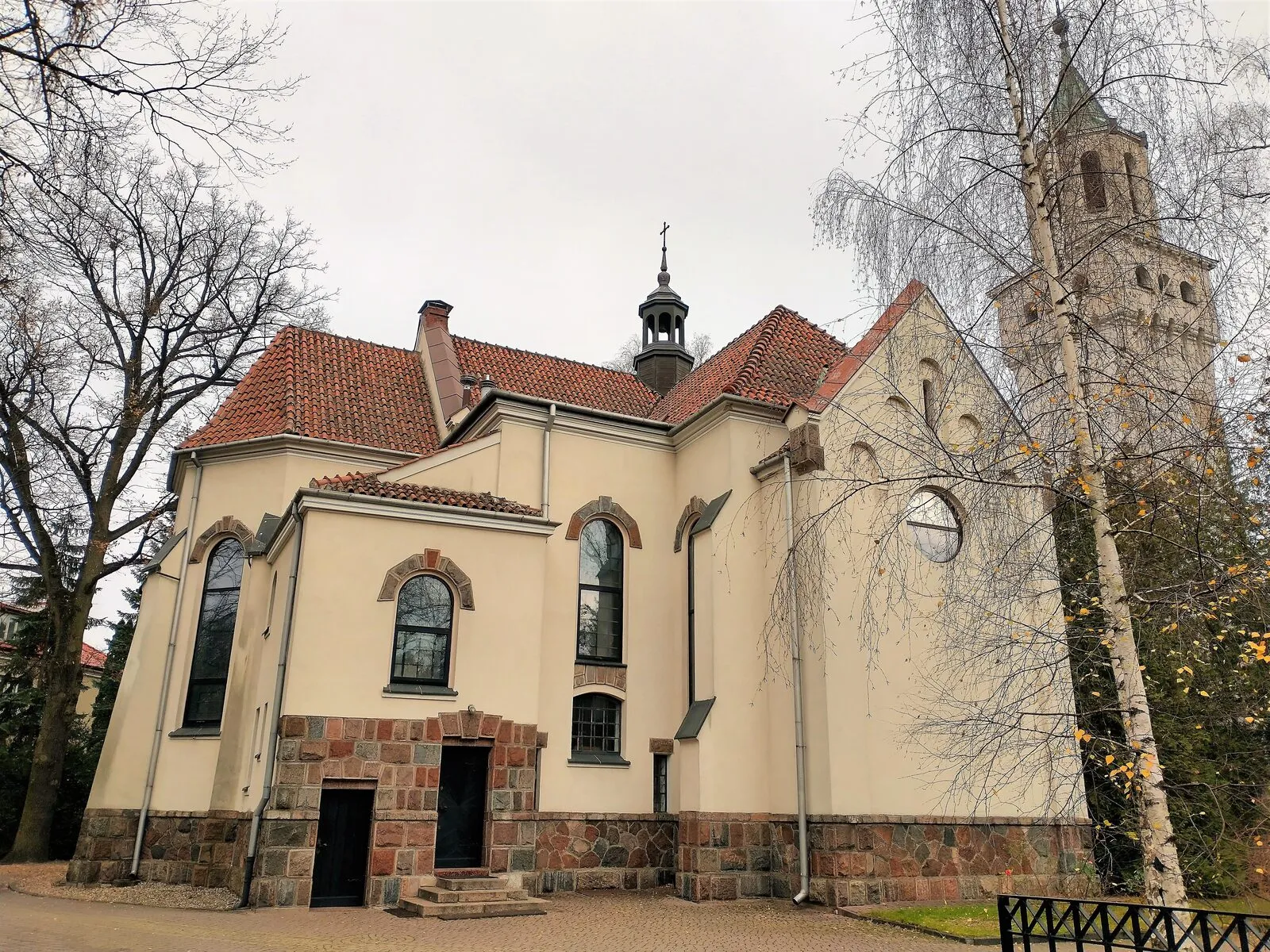 Kościół św. Jadwigi w Milanówku, murowana bryła z kamiennym cokołem i wieżą.
