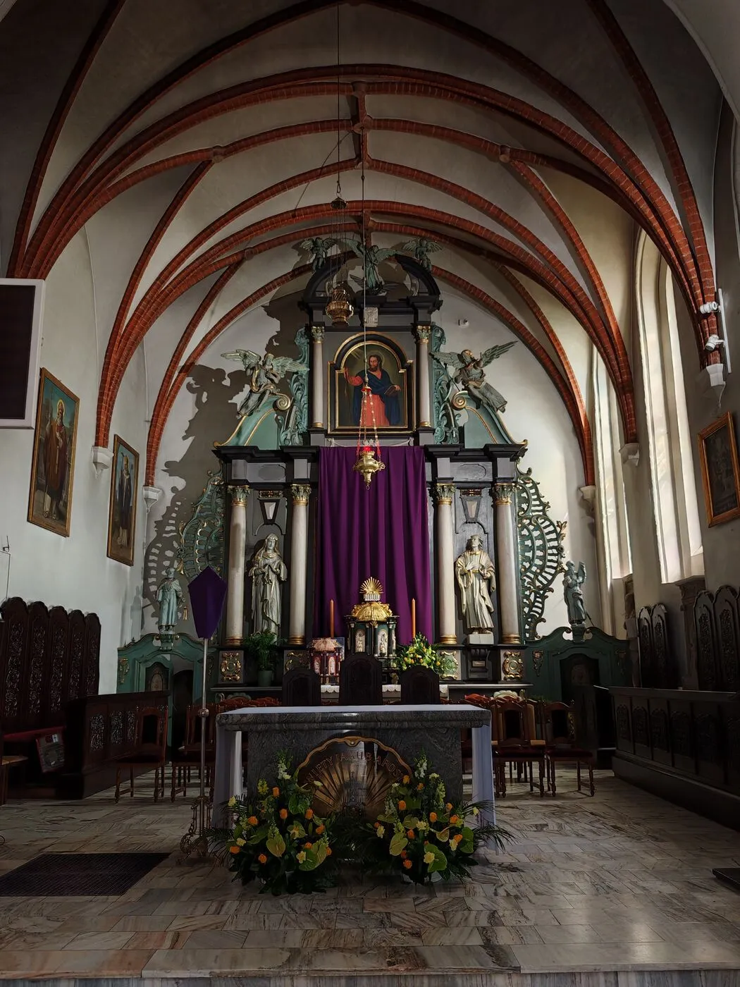 Prezbiterium kościoła z barokowym ołtarzem głównym pod gotyckim sklepieniem.