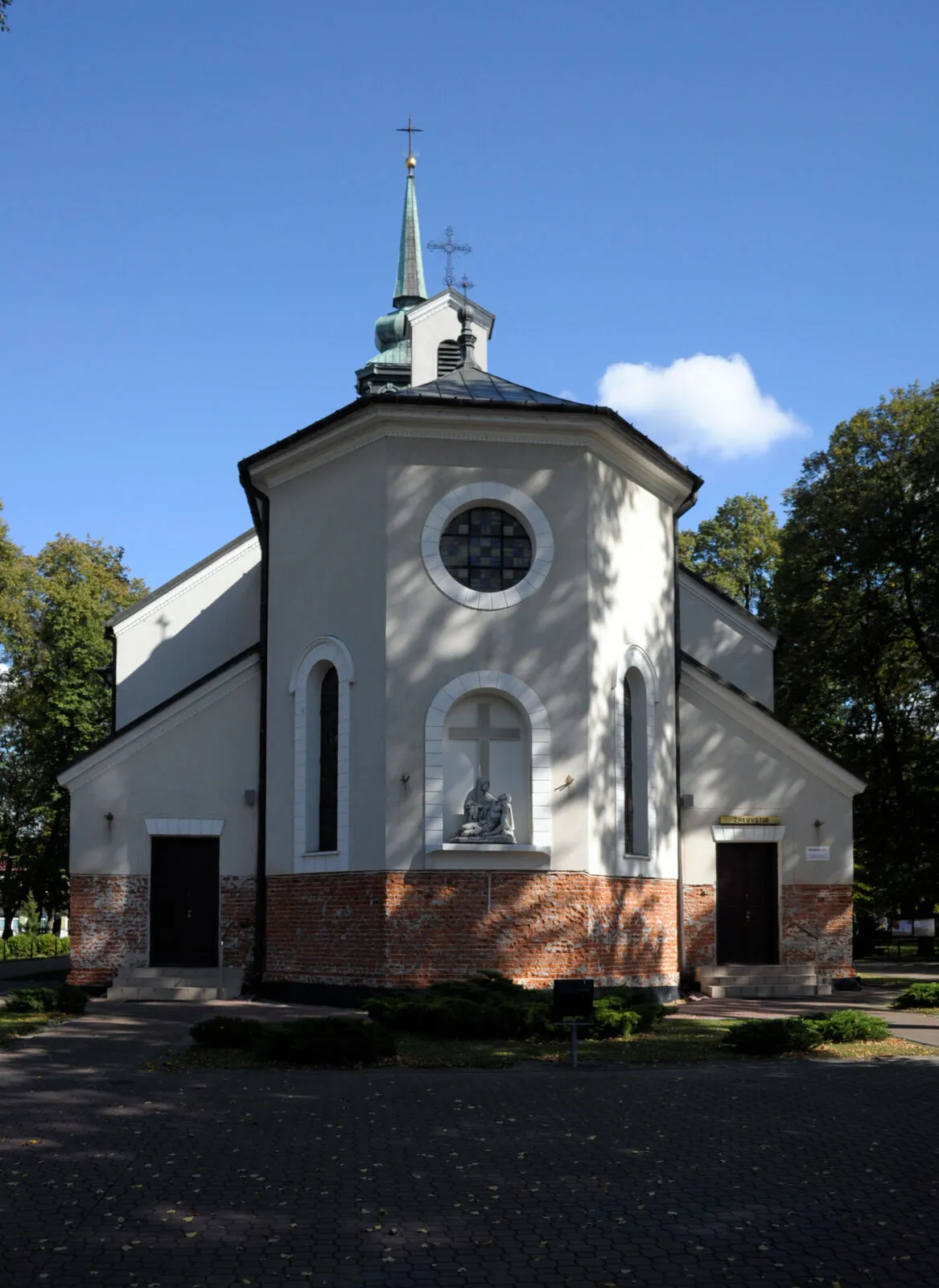 Kościół Świętego Krzyża w Kozienicach z okrągłym oknem i sceną Piety na elewacji