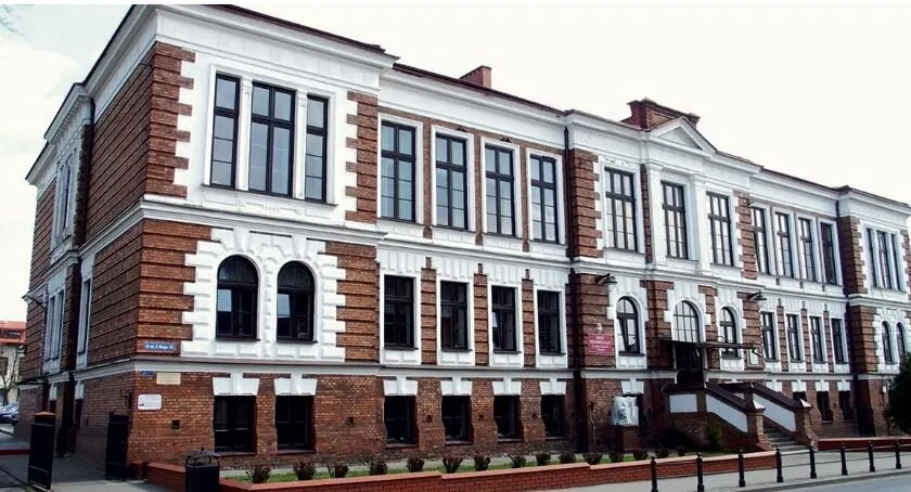 Gmach Liceum im. Kościuszki w Gostyninie z ceglano-tynkową elewacją i bogatym detalem architektonicznym.