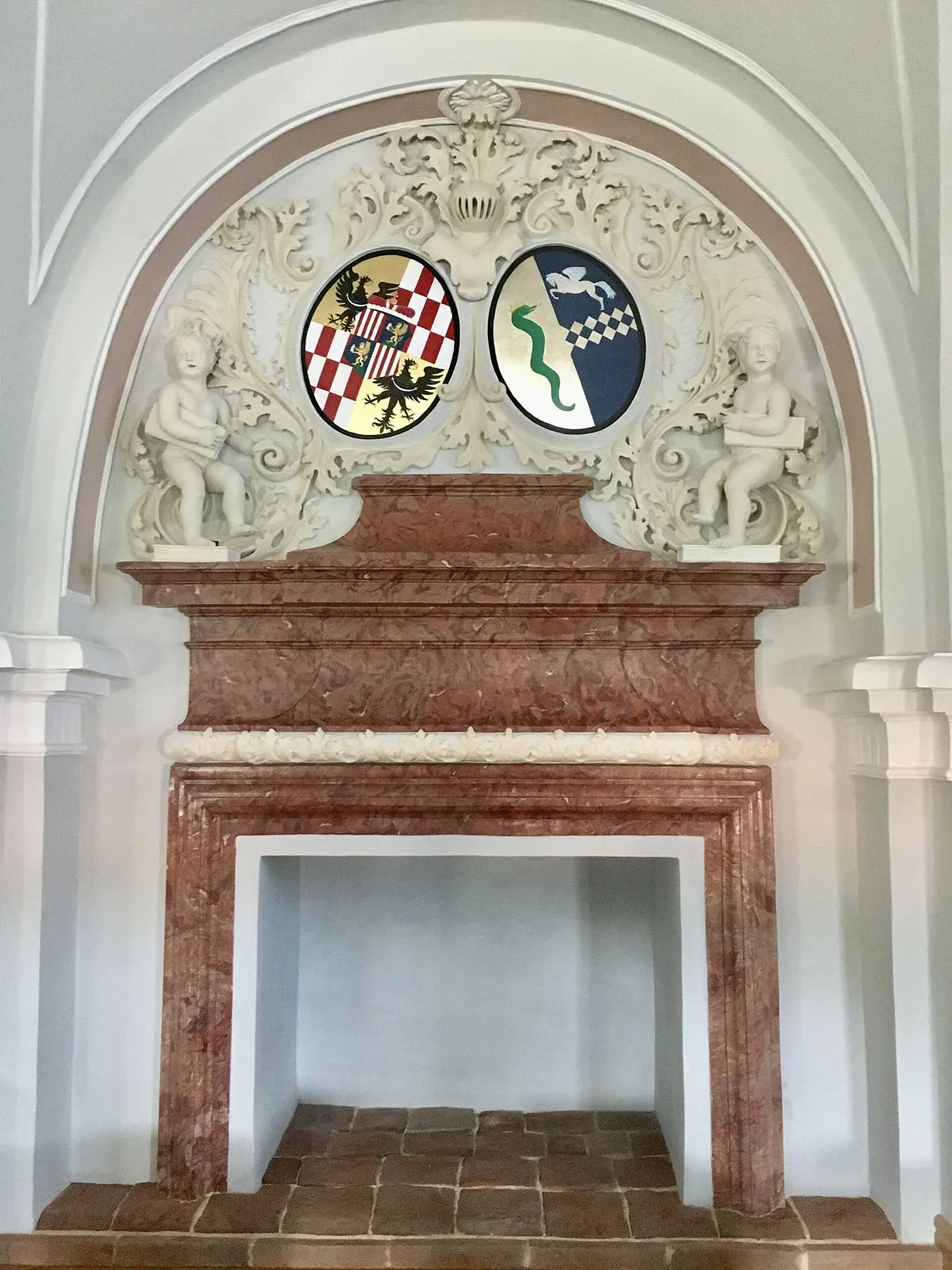Sala z kominkiem ozdobionym sztukaterią z herbami