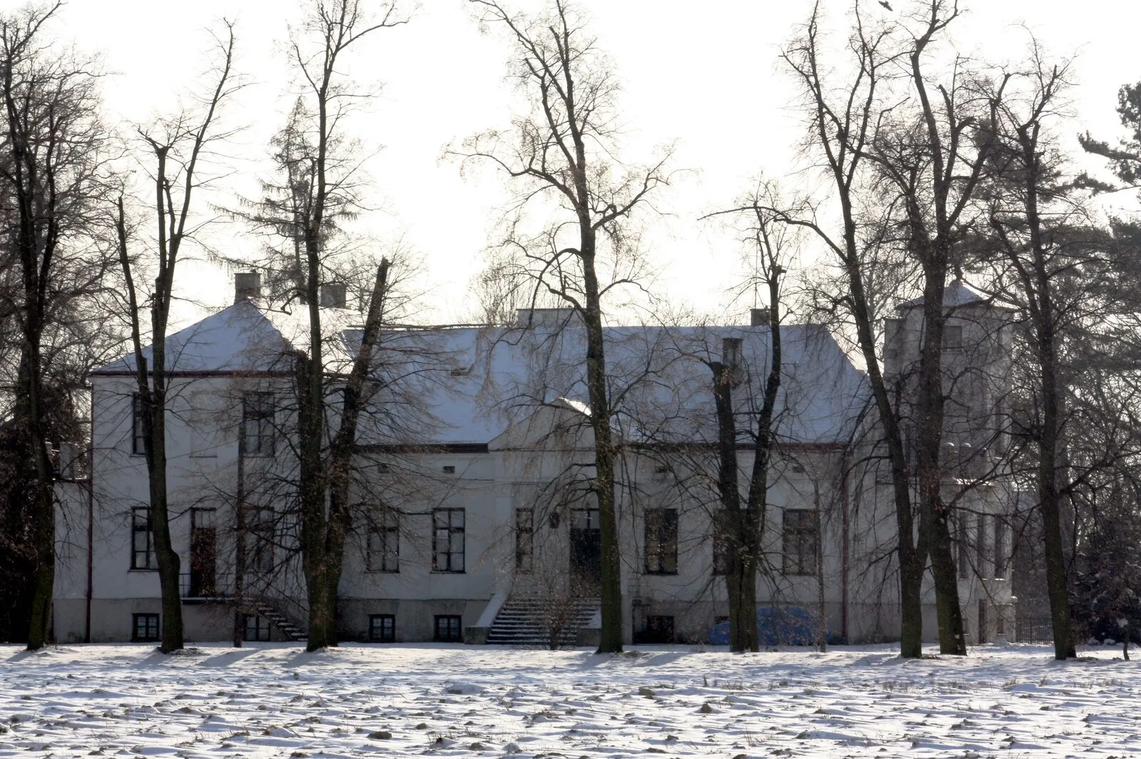 Pałac w Duchnicach za bezlistnymi drzewami zimą