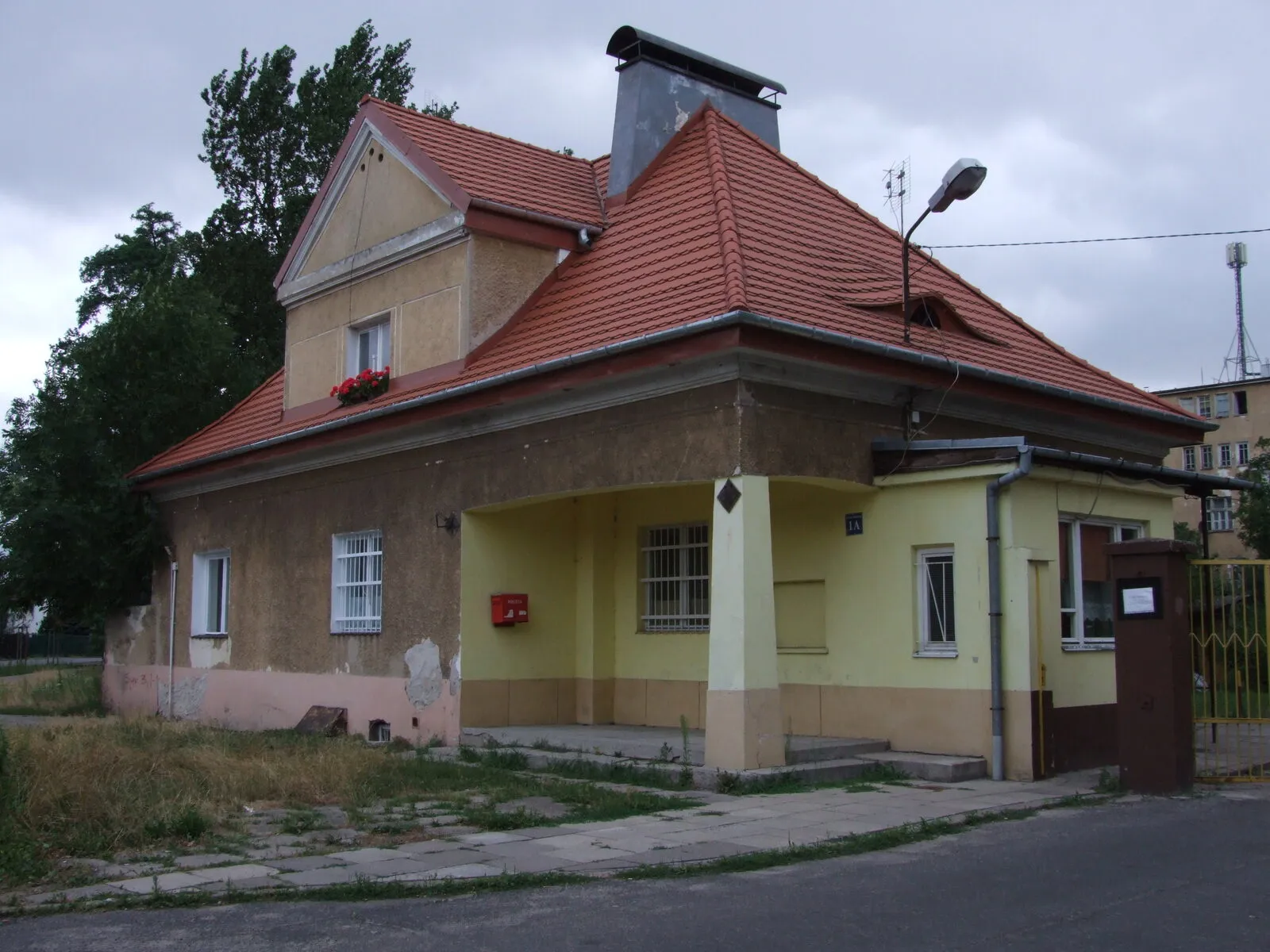 Budynek portierni szpitala Drewnica przy ulicy Rychlińskiego 1A: parterowy, z podcieniem na filarze i kopertowym dachem krytym dachówką.