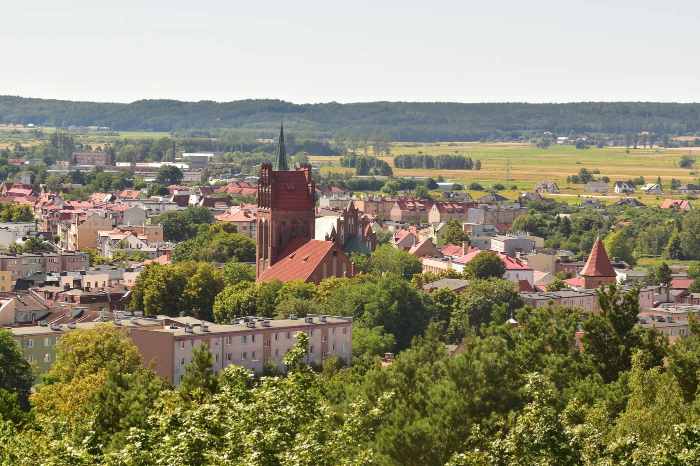 Widok z tarasu wieży na dachy Lęborka, wieżę kościoła św. Jakuba i pola za miastem.