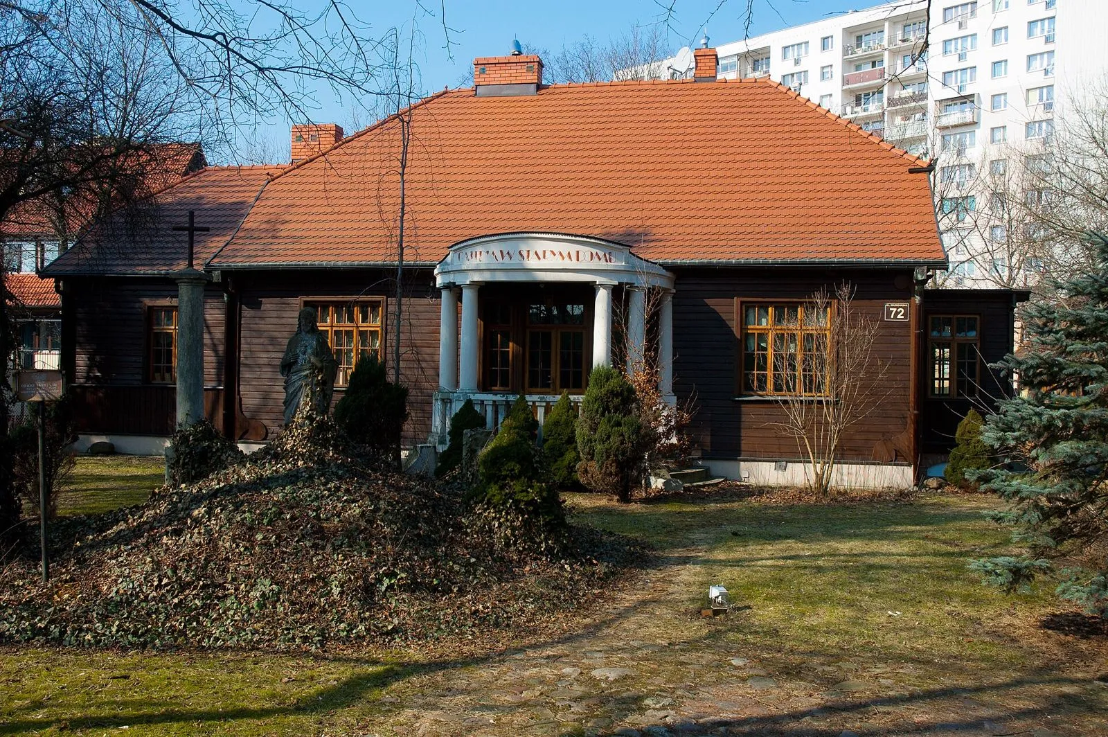 Drewniany dom przy Warszawskiej 72 z półkolistym portykiem.